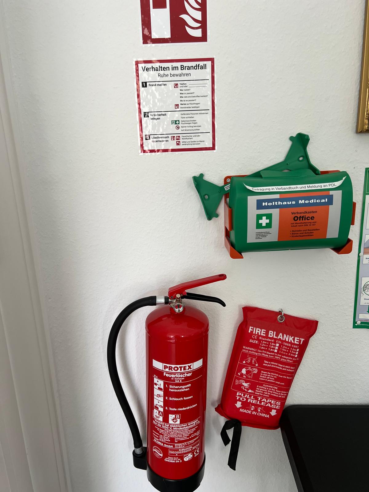 Feuerlöscher mit Verhalten-im-Brandfall-Aushang, Löschdecke und Verbandkasten