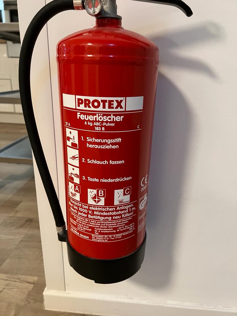 Nahaufnahme Feuerlöscher mit Bedienhinweisen und Löschmittelangaben
